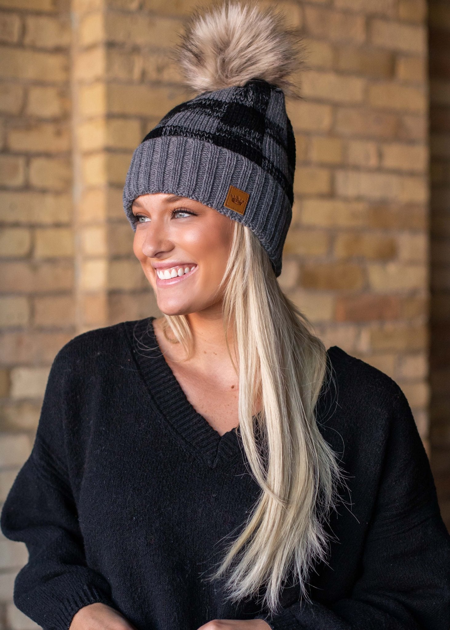 Grey and black buffalo plaid fleece lined knit hat with pom detail