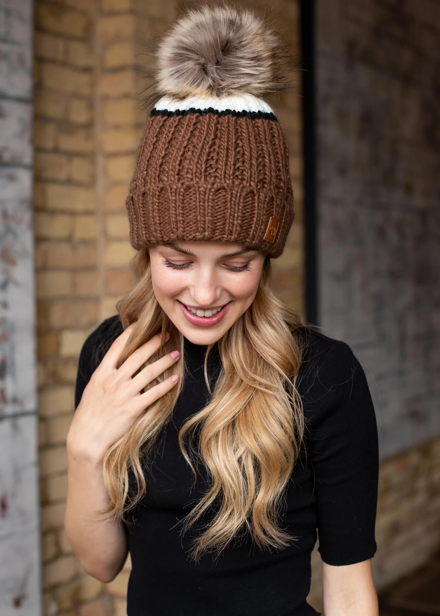 Brown and cream color block knit hat with black stripe pom accent