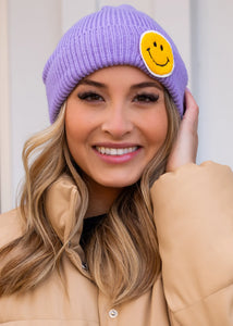 Purple cuffed knit beanie with smiley face patch Women's fitted beanie hat with a smiley face graphic on the front of the hat